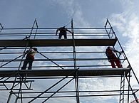Arbeiter stehen auf einem Gerüst