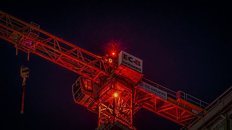Ein Baukran bei Nacht - Symbolbild für düstere Aussichten im Baugewerbe