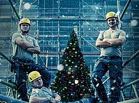 Gerüstbau-Azubis posieren vor einem Weihnachtsbaum