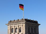 Der Reichstag mit Deutschlandfahne - Symbol für die Bundespolitik