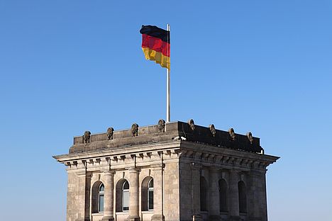 Der Reichstag mit Deutschlandfahne - Symbol für die Bundespolitik