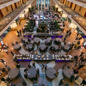 Blick von oben auf die Pausentische und die Ausstellung im Hotelfoyer